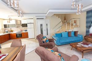 uma sala de estar com um sofá azul e cadeiras em Paradise Town Villa Beltania 100 MBPS free wifi em Belek