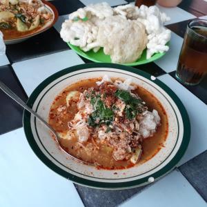 a bowl of food on a table with other plates of food at WIEN HOMESTAY CIREBON - B7 Family Homestay in Cirebon