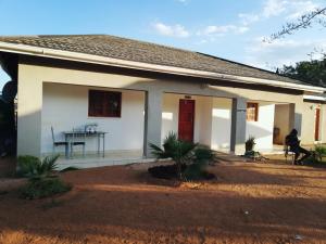 a small white house with a table in it at Mashusha Guest House in Mahalapye