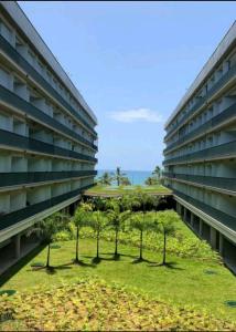 an apartment building with a lawn in the middle of it at Maravilhoso Apartamento Reserva DNA Ubatuba in Ubatuba