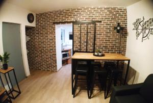 a room with a table and a brick wall at Wanderlust Anduze in Anduze