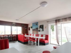 Belvilla by OYO La Casa de Valen في Villamuriel de Cerrato: غرفة طعام مع كراسي حمراء وطاولة
