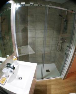 La salle de bains est pourvue d'une douche et d'un lavabo blanc. dans l'établissement Wanderlust Anduze, à Anduze