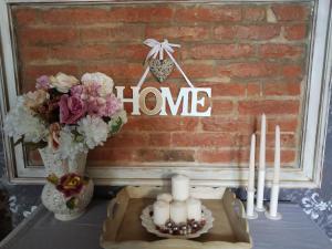 a table with candles and flowers and a home sign at Piccola Casa Shabby 500m castello di Este in Este