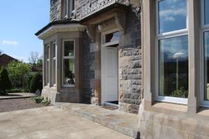 una casa in pietra con porta bianca e finestre di Rosebank a Spean Bridge