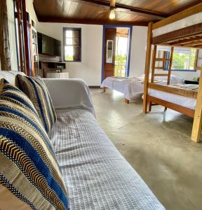 a living room with two beds and a couch at Vila Pequeá Ilhabela in Ilhabela