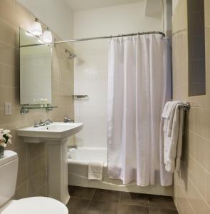 
a bathroom with a shower, toilet, sink and tub at Seton Hotel in New York
