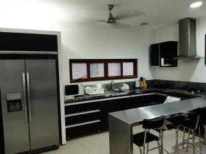 a kitchen with a stainless steel refrigerator and a counter at Lagos del Peñon: Casa 10 - Puerto Madero in Girardot