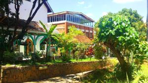 um edifício com uma árvore em frente a um edifício em La Résidence d'Ankerana em Antananarivo