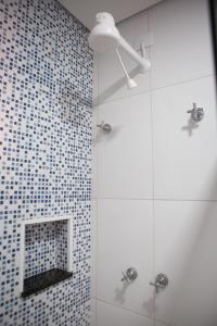 a bathroom with a shower with blue and white tiles at Grande Hotel Atibaia in Atibaia