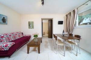 sala de estar con sofá rojo y mesa en Ilias Apartments, en Chrysi Ammoudia