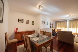 a dining room with a table and a living room at Apartament em condominio com Piscina in Matosinhos