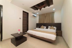 Hotel Sami V Landmarks في Arantāngi: غرفة نوم بسرير كبير وطاولة
