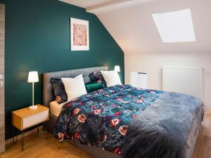 een slaapkamer met een bed en een groene muur bij Superb holiday home in the centre of Aywaille in Aywaille
