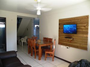 cocina y comedor con mesa y sillas en Duplex com ótimo custo x benefício pertinho da Praia de Mariscal, en Bombinhas
