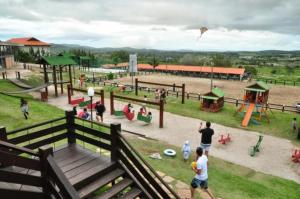 um grupo de pessoas a lançar um papagaio num parque em Flat Fazenda Monte Castelo Gravatá em Gravatá