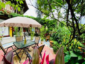 a patio with a table and chairs and plants at Vila Pequeá Ilhabela in Ilhabela