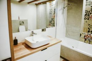 uma casa de banho com um lavatório e um chuveiro em Apartament Myślenice em Myślenice