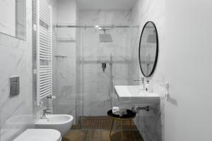 a white bathroom with a sink and a mirror at Aria Boutique Apartments Farneti in Milan