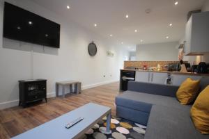 een woonkamer met een blauwe bank en een keuken bij Studio 332 in Hull