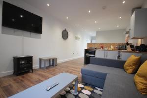 a living room with a blue couch and a kitchen at Studio 332 in Hull