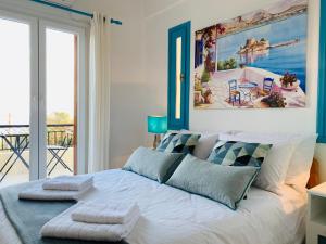 sypialnia z dużym białym łóżkiem z niebieskimi akcentami w obiekcie Villa Serendipity Sea View w mieście Porto Heli +30 zdjęć