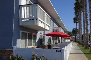 a blue building with a patio with a red umbrella at Seaside Village Carlsbad in Carlsbad