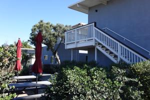 a building with two red umbrellas and some bushes at Seaside Village Carlsbad in Carlsbad