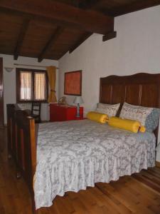 a bedroom with a large bed with yellow pillows at Casa La Bicocca in Valdieri