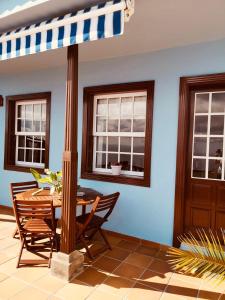una sala da pranzo con tavolo, sedie e finestre di Apartamentos Isla Encantada a Puntallana