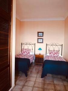 a bedroom with two beds and a table with a lamp at Apartamentos Isla Encantada in Puntallana