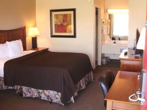 a hotel room with a bed and a bathroom at Trade Winds Central Inn in Tulsa +12 photos