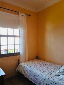 Schlafzimmer mit einem Bett und einem Fenster in der Unterkunft Apartamentos Isla Encantada in Puntallana