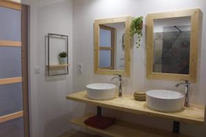 a bathroom with two sinks and two mirrors at Bienvenue chez Philippe et Pascale in Villedieu-les-Poëles