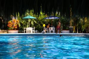 una piscina con personas y sombrillas en Hotel Albatros, en Puerto Escondido