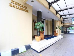 a building with potted plants on the side of it at Puri Jaya Hotel in Jakarta