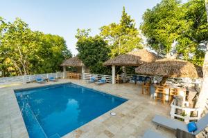 una piscina con tavoli, sedie e ombrelloni di Blue Paloma Bed & Breakfast a Lucea