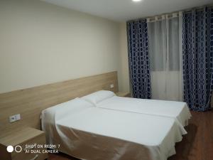 ein Schlafzimmer mit einem weißen Bett und einem Fenster in der Unterkunft ANCLA spaces CON VISTAS AL MAR EGVT436CS in Vinarós
