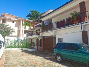 een groene SUV geparkeerd voor een gebouw bij Perla de Sosua in Sosúa