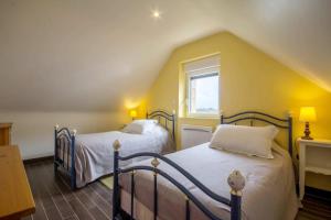 a bedroom with two beds in a attic at Gîte Le Magourin in Belz