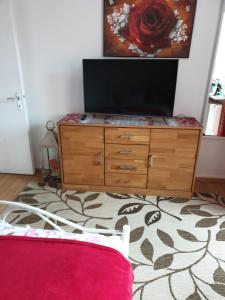 a bedroom with a dresser with a television on it at Piacere Emden in Emden