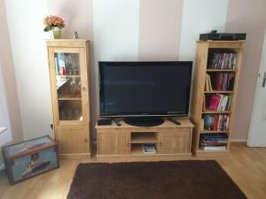uma televisão num suporte de madeira numa sala de estar em Piacere Emden em Emden