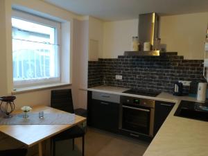 a kitchen with a stove and a table and a window at Taunusrast-Usi in Usingen