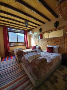 sypialnia z 2 łóżkami i dużym oknem w obiekcie Riad Atlas Imlil w mieście Imlil
