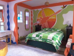 1 dormitorio con 1 cama con una pintura en la pared en Hostal La Casa del Sol, en Copacabana