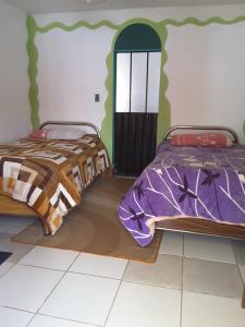 two beds sitting next to each other in a bedroom at Hostal La Casa del Sol in Copacabana