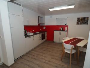 une cuisine avec une table et un mur rouge dans l'établissement Ferienwohnung Sanwald, à Schwäbisch Hall