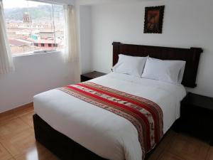 a bedroom with a large white bed with a window at Apartment Samana House in Cusco
