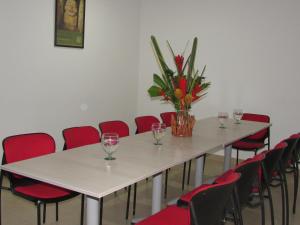 a conference room with a table and chairs with wine glasses at Hotel Yalconia in San Agustín