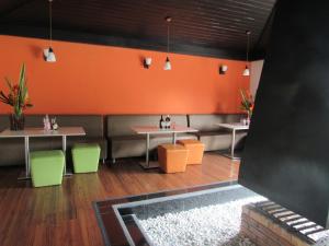 ein Restaurant mit 2 Tischen und Stühlen und orangefarbenen Wänden in der Unterkunft Hotel Yalconia in San Agustín